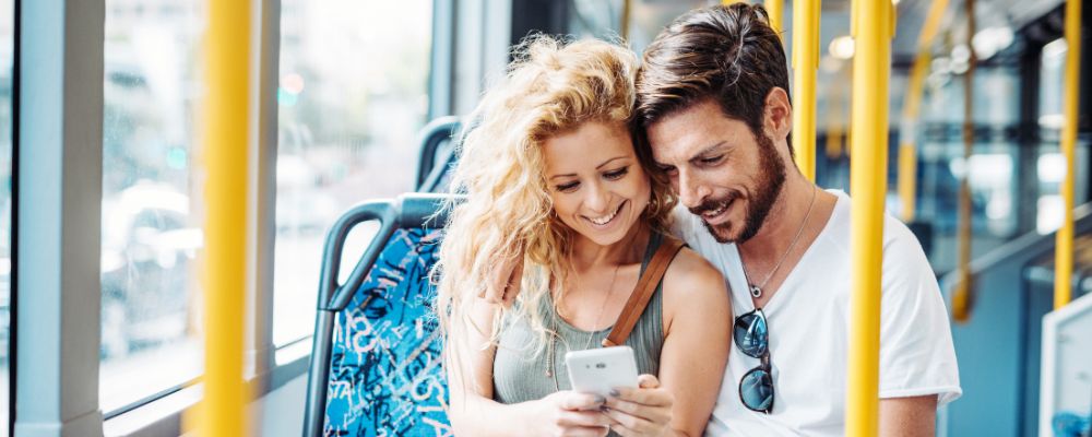 Couple on bus looking at phone